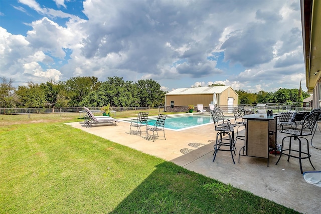 view of pool with a lawn and a patio