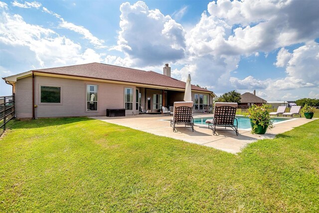 rear view of property with a lawn and a patio area