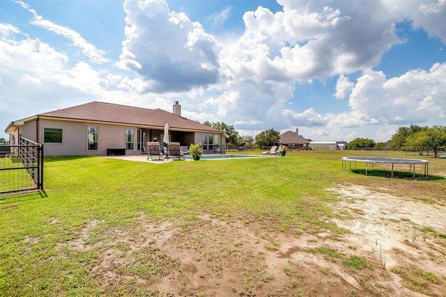 view of yard with a trampoline and a patio area