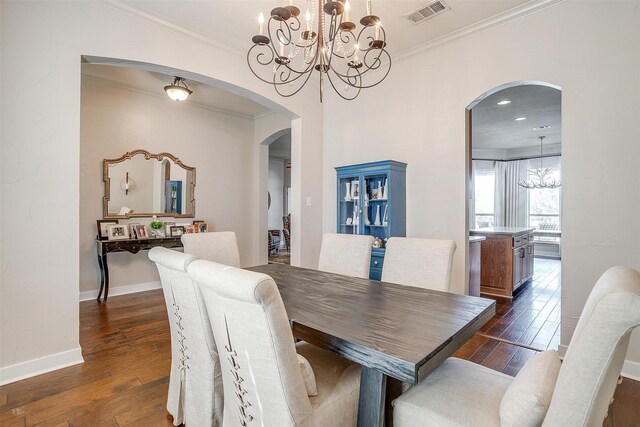 dining area with ornamental molding, dark hardwood / wood-style flooring, and an inviting chandelier