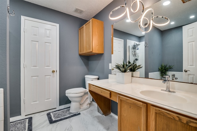 bathroom featuring vanity, toilet, a notable chandelier, and a textured ceiling