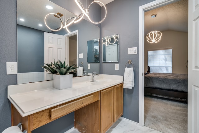 bathroom with a textured ceiling, vanity, a chandelier, and lofted ceiling