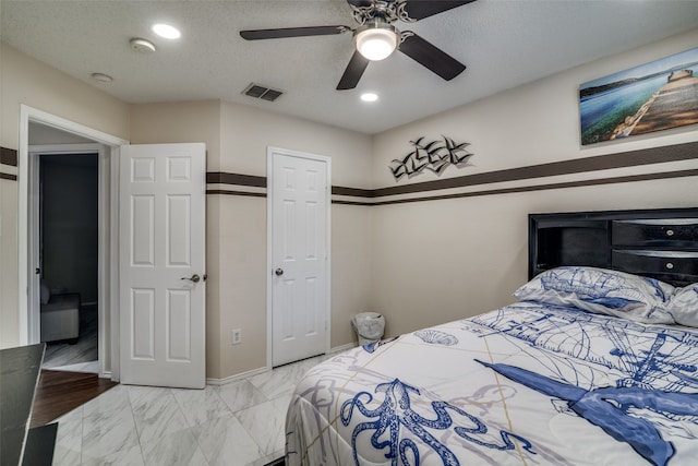 bedroom featuring ceiling fan and a textured ceiling