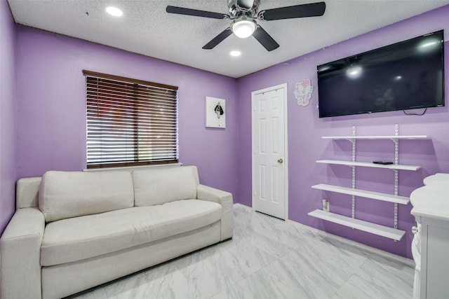 living room with a textured ceiling and ceiling fan