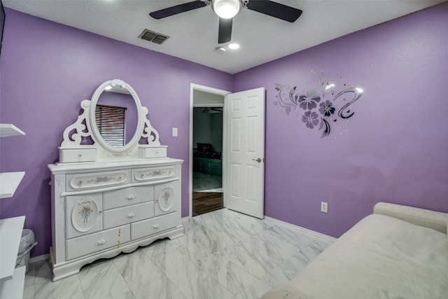 bedroom with a textured ceiling and ceiling fan