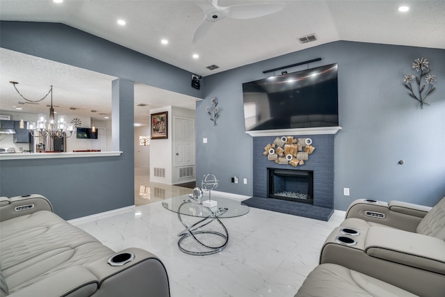 living room with lofted ceiling, ceiling fan with notable chandelier, a textured ceiling, and a brick fireplace