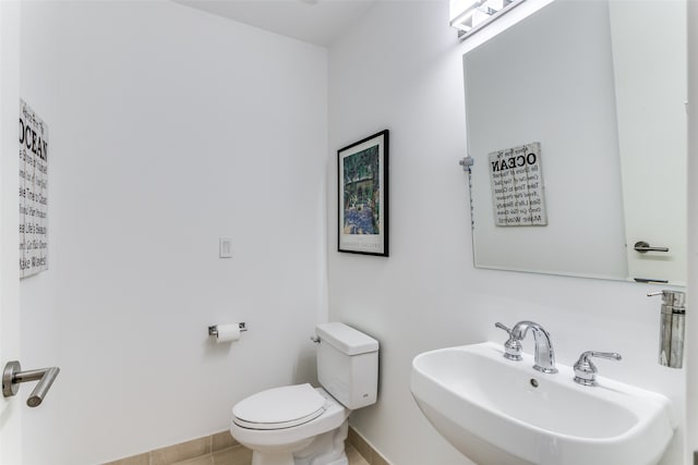 bathroom featuring toilet, sink, and tile patterned floors