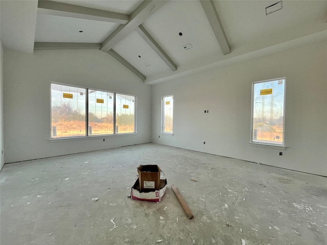 unfurnished room with beam ceiling and high vaulted ceiling