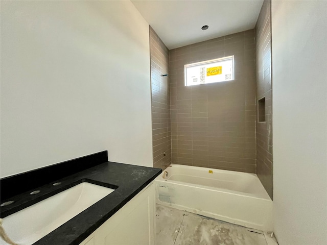 bathroom with vanity and tiled shower / bath