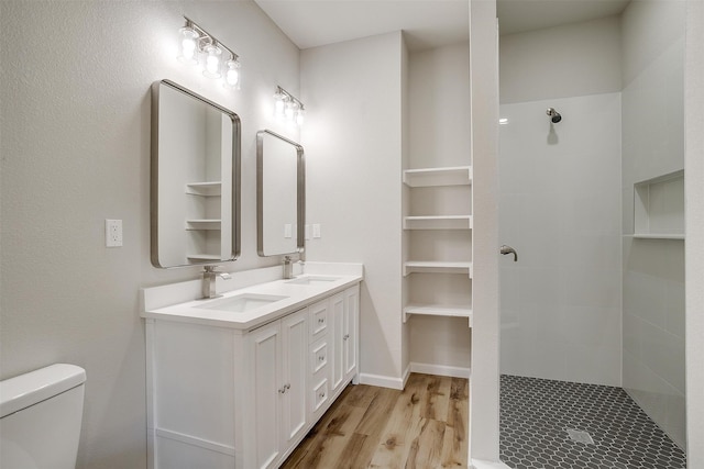 bathroom with a shower, hardwood / wood-style floors, toilet, and vanity