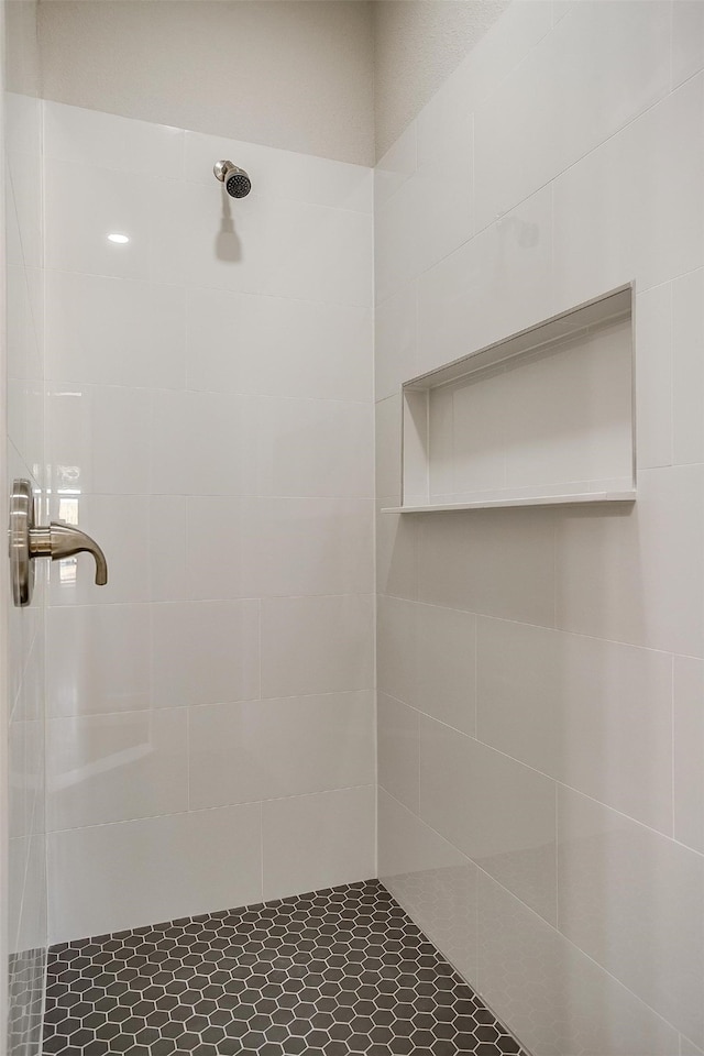 bathroom with tiled shower and tile patterned floors