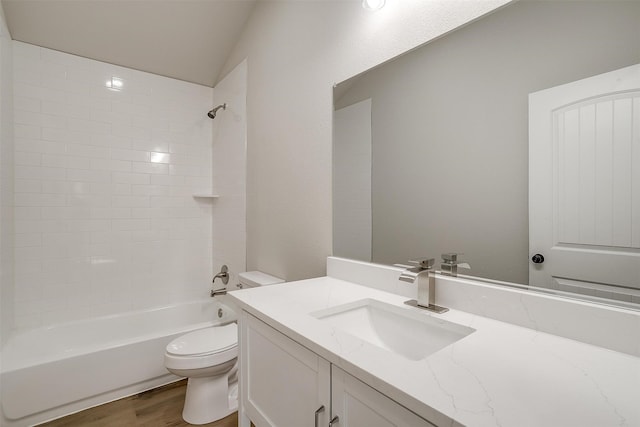 full bathroom featuring hardwood / wood-style flooring, lofted ceiling, vanity, tiled shower / bath, and toilet