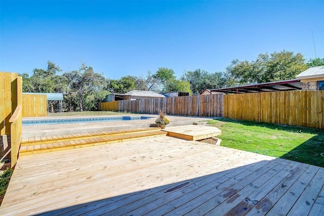 wooden deck featuring a lawn and an empty pool