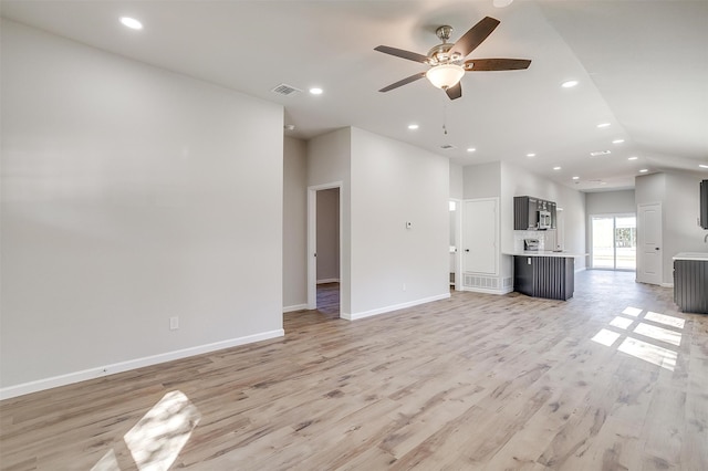 unfurnished living room featuring ceiling fan and light hardwood / wood-style floors