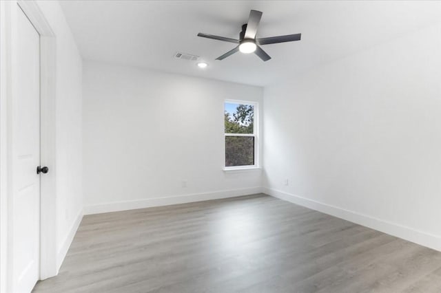 spare room with ceiling fan and light wood-type flooring