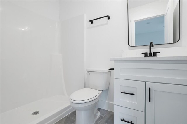 bathroom featuring tile patterned flooring, vanity, toilet, and walk in shower