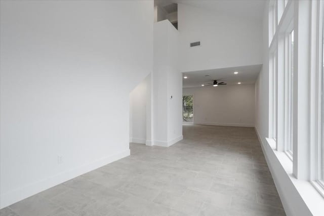 interior space featuring ceiling fan and a high ceiling