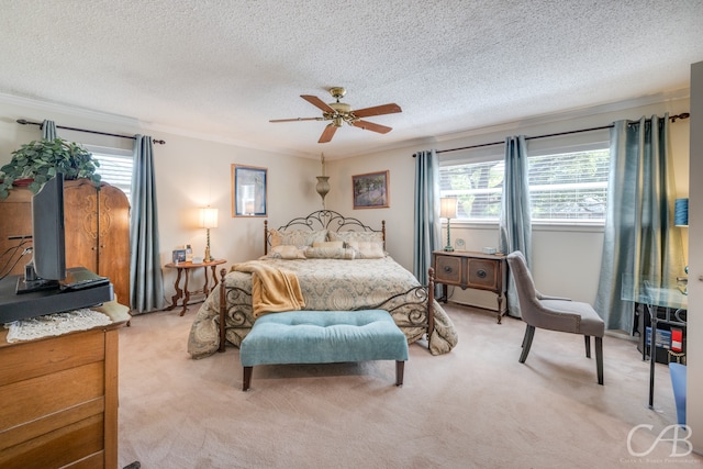 bedroom with ceiling fan, ornamental molding, light carpet, and a textured ceiling