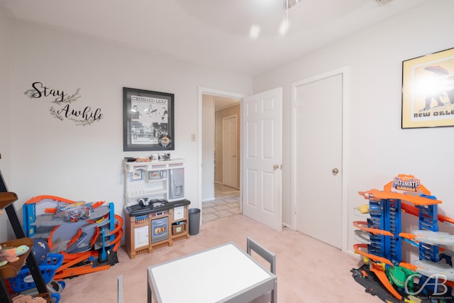 recreation room featuring light colored carpet