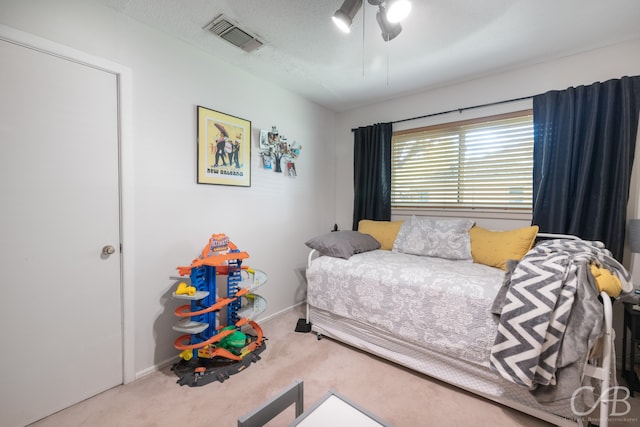 carpeted bedroom with a textured ceiling and ceiling fan