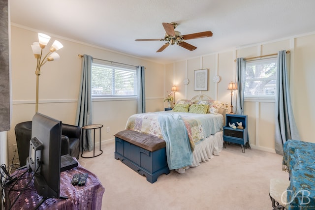 carpeted bedroom with ceiling fan, ornamental molding, and multiple windows