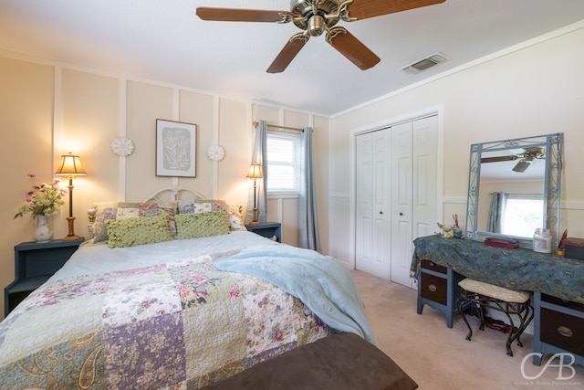 bedroom with multiple windows, ceiling fan, light colored carpet, and a closet