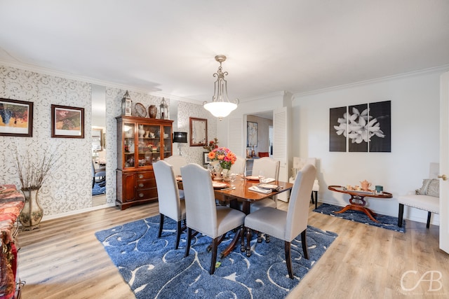 dining space with light wood-type flooring and ornamental molding