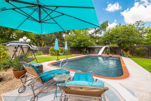 view of pool with a water slide and a patio area