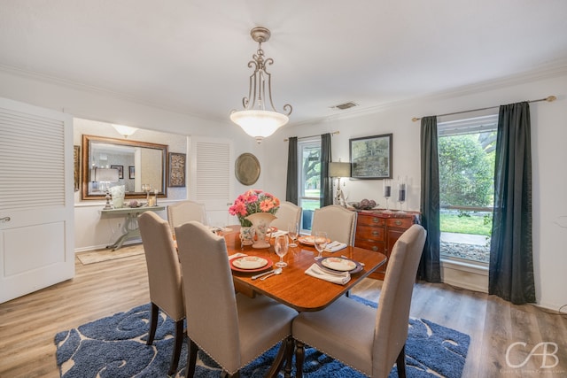 dining room featuring ornamental molding and light hardwood / wood-style flooring