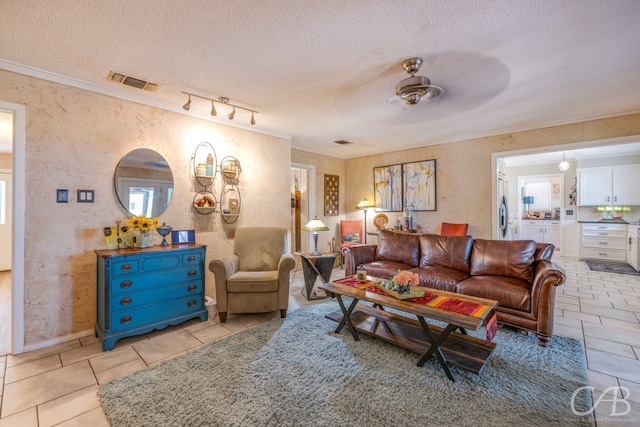 living room featuring a textured ceiling, ceiling fan, ornamental molding, and light tile patterned flooring