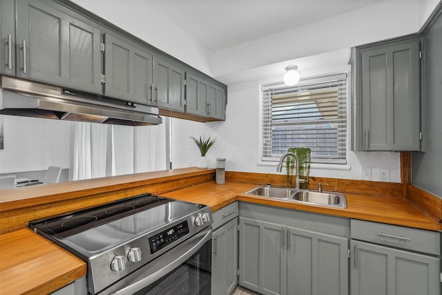 kitchen featuring wooden counters, gray cabinetry, electric range, and sink