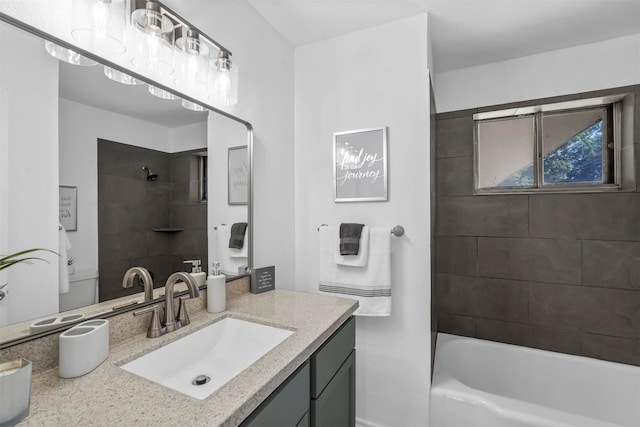 bathroom featuring tiled shower / bath combo and vanity