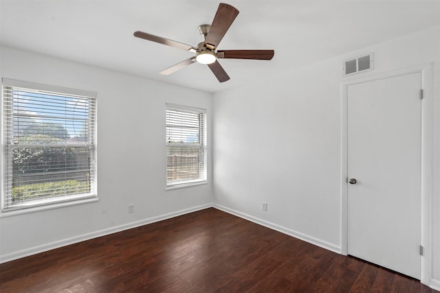 empty room with ceiling fan and dark hardwood / wood-style floors