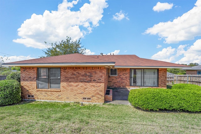 rear view of property featuring a lawn