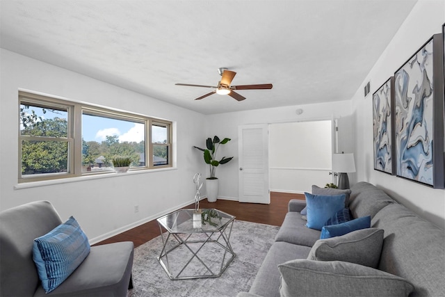 living room featuring ceiling fan and dark hardwood / wood-style flooring