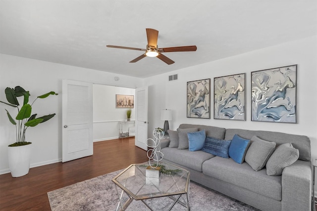 living room with ceiling fan and dark wood-type flooring