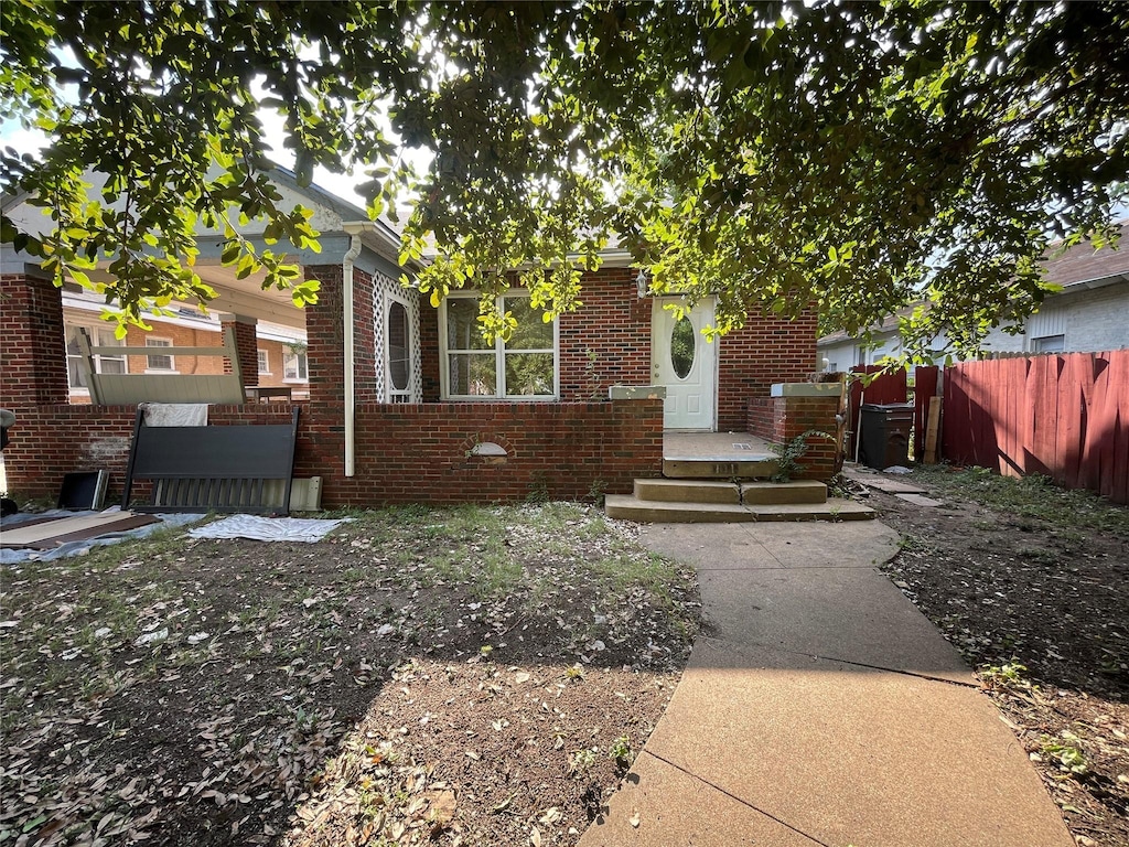 view of front of house with brick siding and fence