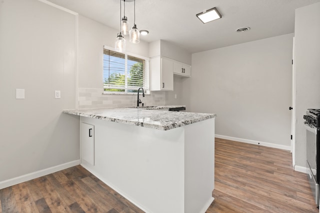 kitchen with white cabinets, decorative light fixtures, dark hardwood / wood-style floors, and kitchen peninsula