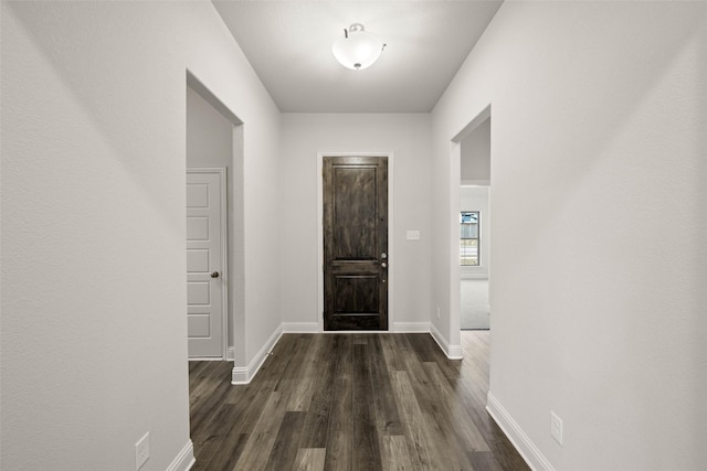 entrance foyer featuring baseboards and dark wood finished floors