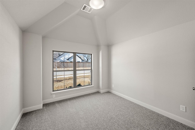 carpeted empty room with vaulted ceiling, visible vents, and baseboards