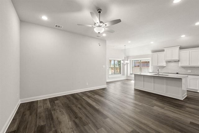 kitchen with a sink, visible vents, white cabinets, decorative backsplash, and dark wood-style floors