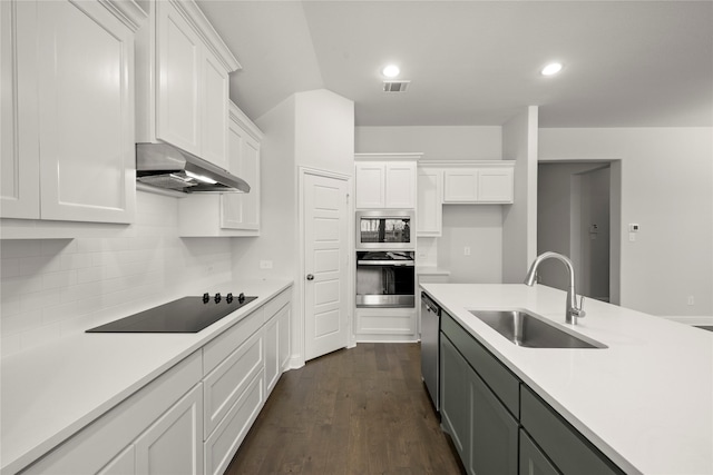 kitchen featuring under cabinet range hood, a sink, white cabinetry, light countertops, and appliances with stainless steel finishes