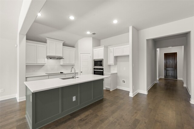 kitchen with wall oven, black electric cooktop, under cabinet range hood, a sink, and built in microwave