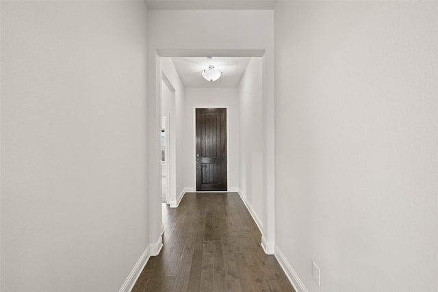 hallway with baseboards and dark wood-style flooring