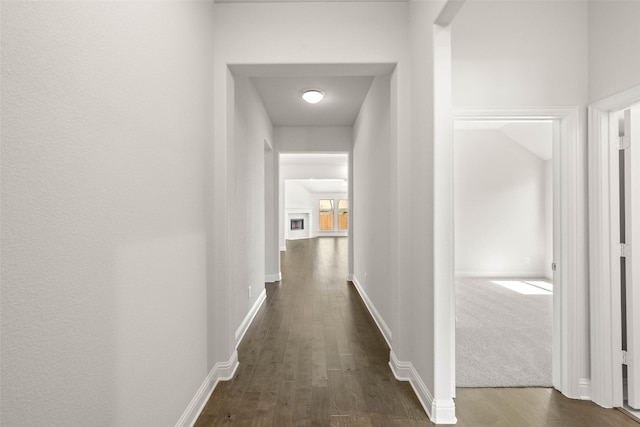 hallway with dark wood finished floors and baseboards