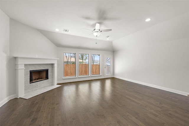 unfurnished living room with baseboards, visible vents, dark wood-style floors, vaulted ceiling, and a fireplace