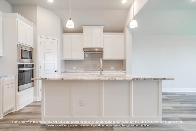 kitchen featuring light stone counters, appliances with stainless steel finishes, decorative light fixtures, and white cabinets