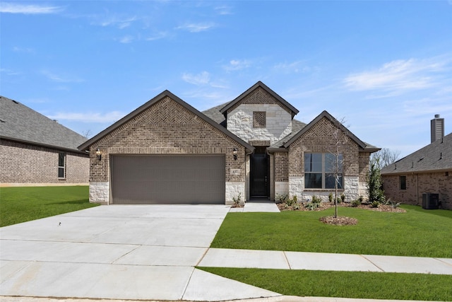 french provincial home with stone siding, concrete driveway, a front yard, an attached garage, and brick siding