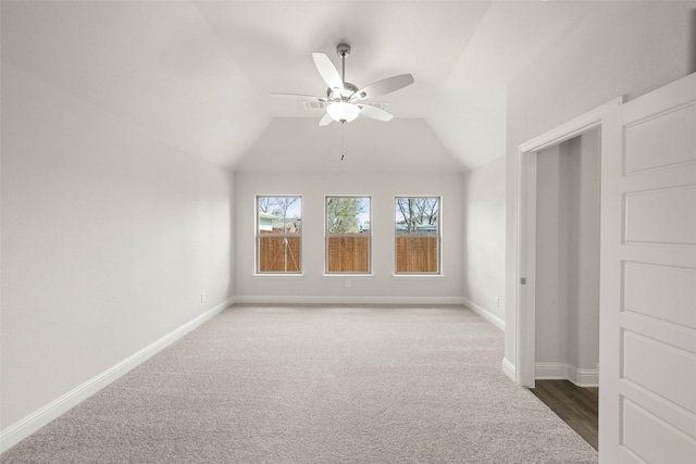 unfurnished room featuring a ceiling fan, lofted ceiling, baseboards, and carpet floors