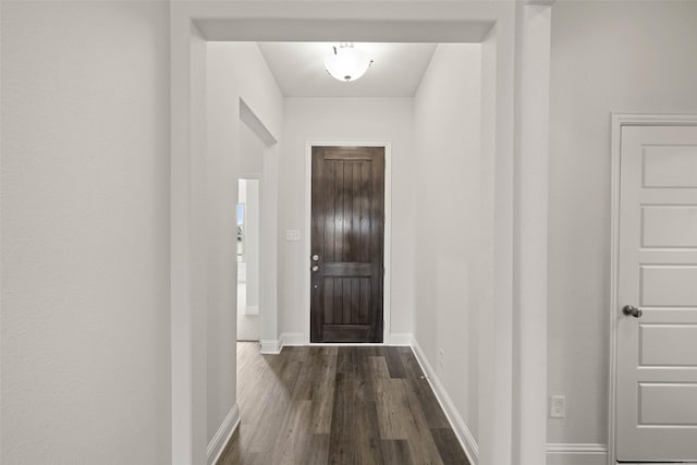 entryway featuring baseboards and dark wood-style floors